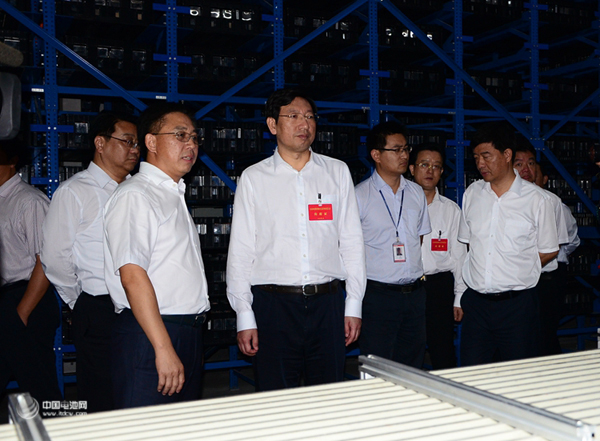 國軒高科董事長李縝正在向省委常委、宣傳部長曹征海（左二）介紹電池工藝流程 