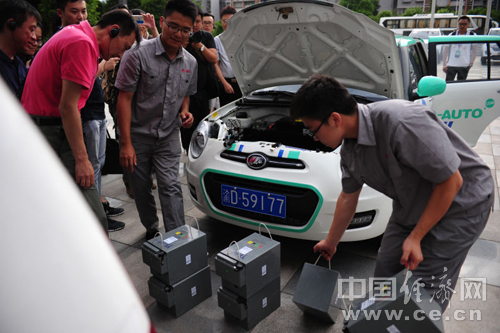 力帆汽車研發(fā)生產(chǎn)的電動(dòng)汽車，工作人員正在為車輛替換電源。