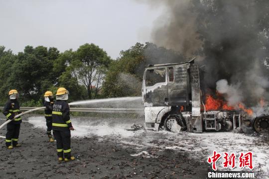 攝消防官兵利用泡沫水槍對車頭實施撲救。 王基達 攝 攝消防官兵利用泡沫水槍對車頭實施撲救。 王基達 攝