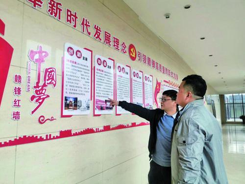 贛鋒鋰業黨總支書記黃韶勇（左）向記者介紹黨建工作有關情況